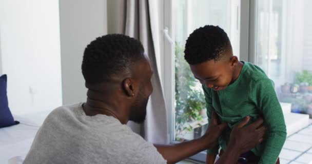 Afroamerikanischer Vater Hilft Seinem Sohn Beim Anziehen Schlafzimmer Während Der — Stockvideo