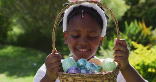 Усміхнений Афроамериканський Хлопчик Великодніх Вухах Тримає Кошик Пасхальних Яєць Саду — стокове відео