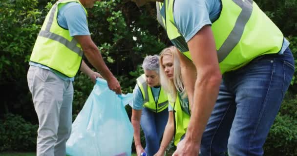 白种人多代男女志愿者在田里捡垃圾 环保义工在乡郊清理 — 图库视频影像