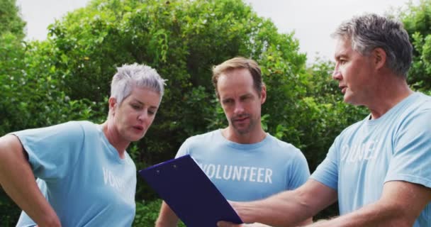 Caucasian Senior Couple Clipboard Man Wearing Volunteer Shirts Talking Field — Stock Video