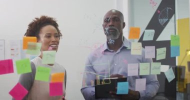 Çeşitli iş adamları ve iş kadınları saydam yönetim kurulu tarafından notlarla beyin fırtınası yapıp gülümsüyor. Yoğun bir modern ofiste çalışıyor..