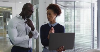 Çeşitli erkek ve kadın iş arkadaşları konuşuyor. Dizüstü bilgisayarı olan bir kadın. İş profesyonelleri ve yoğun modern ofiste çalışıyorlar..