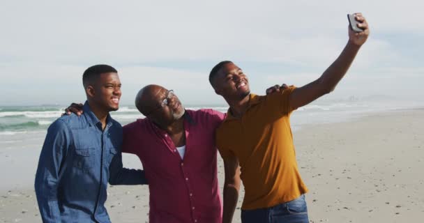 Afroamerikanska Äldre Far Och Tvillingtonåriga Söner Som Står Strand Med — Stockvideo