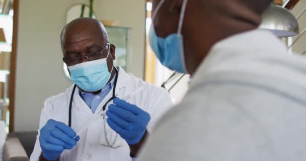 Médico Afroamericano Sénior Dando Prueba Covid Paciente Masculino Casa Usando — Vídeo de stock