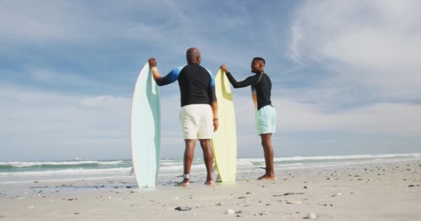 Padre Afroamericano Hijo Adolescente Pie Playa Sosteniendo Tablas Surf Hablando — Vídeo de stock