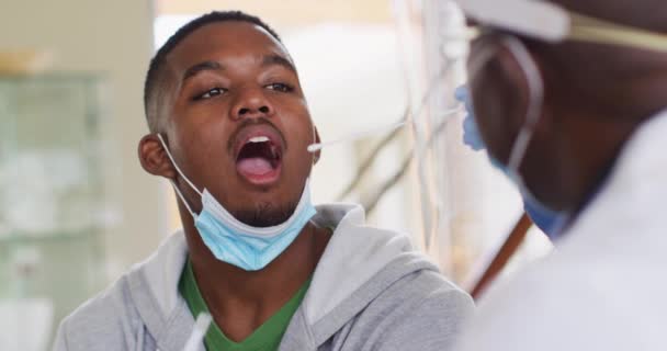 Afrika Kökenli Amerikalı Kıdemli Erkek Doktor Erkek Hastaya Yüz Maskesi — Stok video