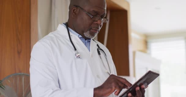 African American Senior Male Doctor Wearing White Coat Writing Notebook — Stock Video