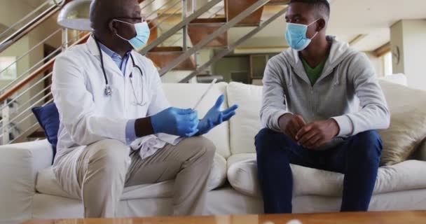 Afroamerykanin Starszy Rangą Lekarz Robiący Męskie Badania Domu Maskach Twarz — Wideo stockowe