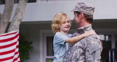 Üniformalı beyaz asker babası oğlunu bahçeden alıyor. Usta asker eve dönüş konsepti