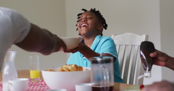 アフリカ系アメリカ人の少年は家で家族と朝食を共にしながら笑っている 幸福の概念は — ストック動画