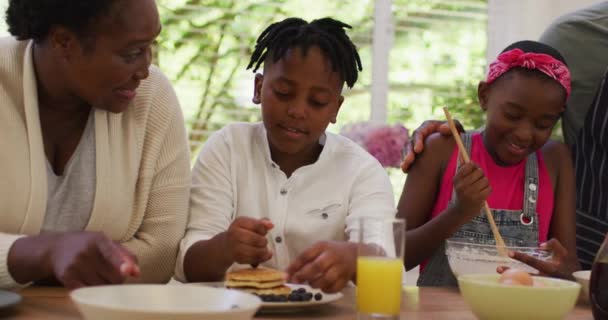 非裔美国人祖父母和孙子孙女在家里厨房里准备煎饼 团聚和幸福的概念 — 图库视频影像