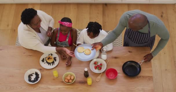 非洲裔美国祖父母和孙子孙女在厨房准备煎饼的俯瞰画面 团聚和幸福的概念 — 图库视频影像