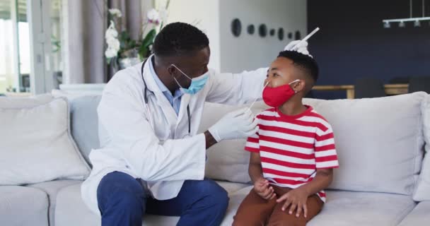 Médico Afro Americano Usando Máscara Facial Tomando Uma Amostra Esfregaço — Vídeo de Stock