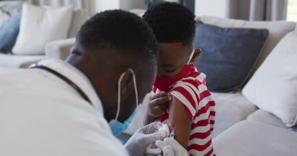 Afro Amerikaanse Dokter Draagt Gezichtsmasker Injecteert Covid Vaccin Een Jongen — Stockvideo