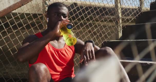 Втомлений Афроамериканець Сидить Ючи Пляшки Води Робить Перерву Вправах Відкритому — стокове відео