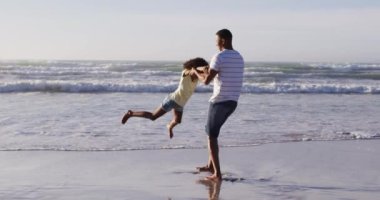 Afrikalı Amerikalı baba ve kızı sahilde oynuyorlar. sağlıklı açık hava eğlence zamanı deniz kenarında.