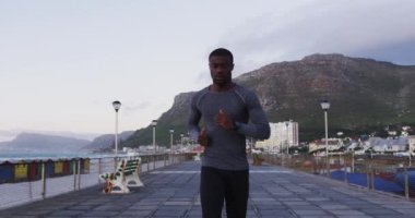 Odaklanmış Afro-Amerikan adam dışarıda egzersiz yapıyor, deniz kenarında koşuyor. fitness, aktif ve sağlıklı yaşam tarzı konsepti.