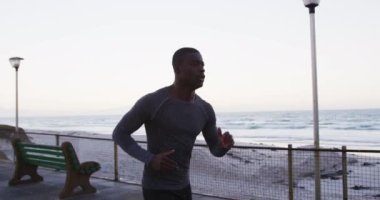 Odaklanmış Afro-Amerikan adam dışarıda egzersiz yapıyor, deniz kenarında koşuyor. fitness, aktif ve sağlıklı yaşam tarzı konsepti.