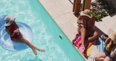 Hasır şapka giyen, bilardoda kadehlerini kaldırırken eğlenen bir grup kadın arkadaş. Bayan arkadaşlar birlikte vakit geçiriyorlar..