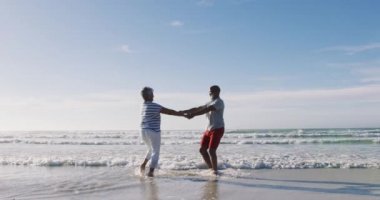 Kıdemli Afro-Amerikan çift sahilde dans ediyor. sağlıklı açık hava eğlence zamanı deniz kenarında.