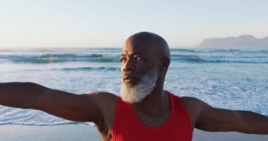 Kıdemli Afro-Amerikan adam plajda yoga yapıyor. sağlıklı açık hava eğlence zamanı deniz kenarında.