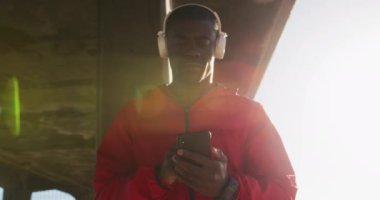 Afrika kökenli Amerikalı adam deniz kenarındaki egzersiz sırasında akıllı telefonu kontrol ediyor. fitness, sağlıklı ve aktif yaşam tarzı konsepti.