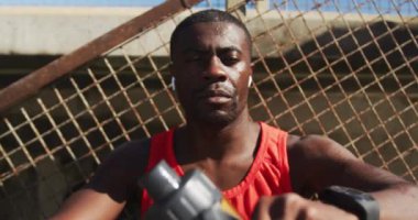 Yorgun Afrikalı Amerikalı adam su şişesinden içiyor, dışarıda egzersiz yapıyor. fitness, sağlıklı ve aktif yaşam tarzı konsepti.