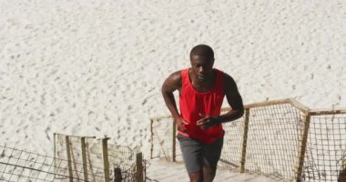 Odaklanmış Afro-Amerikalı koşuyor, deniz kenarında egzersiz yapıyor. fitness, sağlıklı ve aktif yaşam tarzı konsepti.