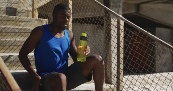 Cansado Afro Americano Sentado Segurando Garrafa Água Fazendo Uma Pausa — Vídeo de Stock