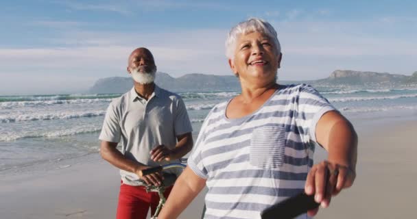 Sonriendo Pareja Afroamericana Mayor Caminando Con Bicicletas Tomando Una Selfie — Vídeo de stock