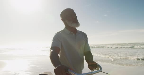 Homem Americano Africano Sênior Caminhando Com Uma Bicicleta Praia Tempo — Vídeo de Stock