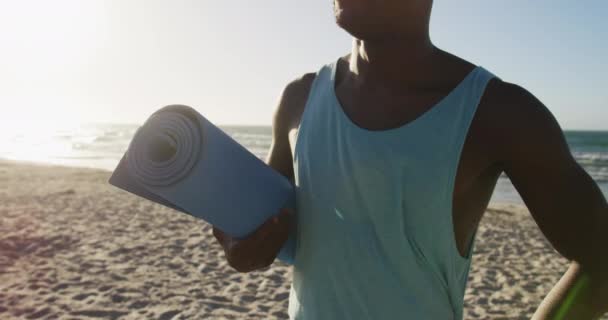 Souriant Homme Afro Américain Tenant Tapis Yoga Debout Sur Plage — Video