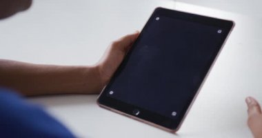 Afro-Amerikalı iş kadını masamızda oturmuş fotokopi çekilen tabletle video görüşmesi yapıyor. bağımsız yaratıcı tasarım işi.