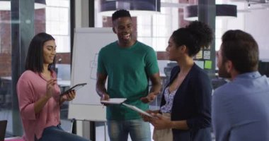 Karışık ırk iş arkadaşları toplantı odasında oturmuş tartışıyorlar. bağımsız yaratıcı tasarım işi.