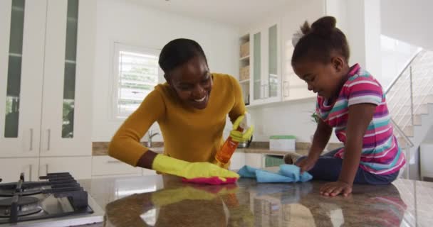 아프리카 미국인 어머니와 카운터를 청소하고 부엌에서 웃음짓고 있습니다 봉쇄되어 동안자기 — 비디오