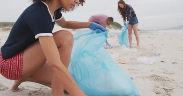 ビーチからゴミを集めるラテックス手袋を身に着けている女性の友人の多様なグループ 生態系のビーチ保全ボランティア — ストック動画
