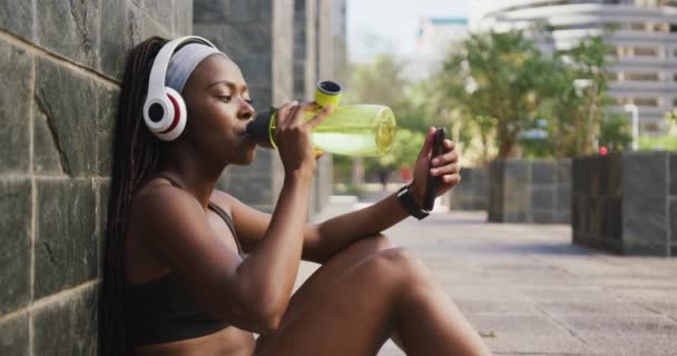 Afroamerykanka Ćwicząca Świeżym Powietrzu Wodę Pitną Korzystająca Smartfona Mieście Zdrowy — Wideo stockowe