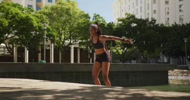Mujer Afroamericana Con Auriculares Inalámbricos Haciendo Ejercicio Aire Libre Saltando — Vídeos de Stock