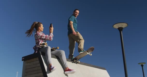 Šťastná Běloška Fotí Svého Přítele Skateboardistu Létě Poflakovat Bruslovém Parku — Stock video