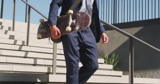 Midsection Homem Negócios Caucasiano Que Anda Baixo Segurando Skate Dia — Vídeo de Stock