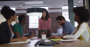 Karışık ırk işkadınlarının toplantı odasında iş arkadaşlarıyla toplantısı var. bağımsız yaratıcı tasarım işi.