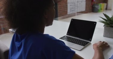 Afrika kökenli Amerikalı iş kadını masamda oturmuş bilgisayarını kullanarak kopya alan bir video görüşmesi yaptırıyor. bağımsız yaratıcı tasarım işi.