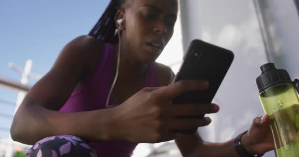 Mujer Afroamericana Sonriendo Mientras Usa Teléfono Inteligente Sentado Las Escaleras — Vídeos de Stock