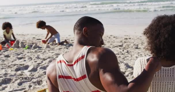 Afrikanische Kinder Spielen Mit Sand Strand Ihre Eltern Umarmen Sich — Stockvideo