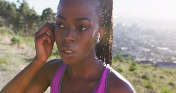 Femme Afro Américaine Faisant Exercice Extérieur Mettant Des Écouteurs Sans — Video