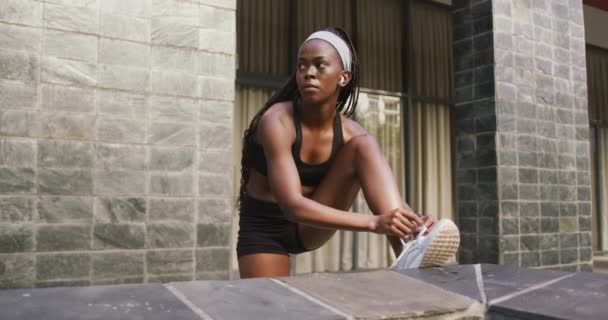 Mujer Afroamericana Haciendo Ejercicio Aire Libre Usando Auriculares Inalámbricos Atando — Vídeos de Stock