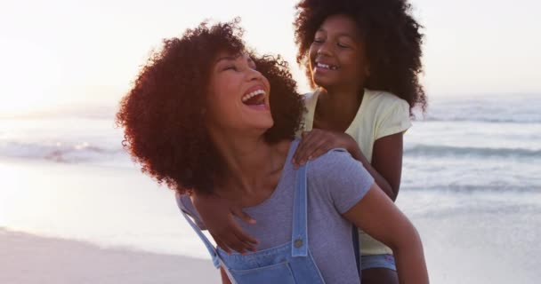非洲裔美国母亲在海滩给她的女儿搭便车 家庭旅游度假的概念 — 图库视频影像
