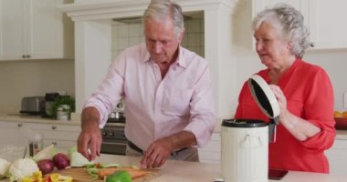 Mutfakta yemek hazırlayan, sebze gübresi hazırlayan mutlu beyaz çift. Karantina süresince evde tecrit altında..