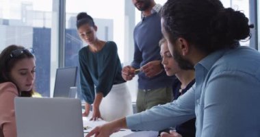 Çeşitli erkek ve kadın yaratıcı meslektaşlar dizüstü bilgisayarla masada toplandılar. Modern bir ofiste bağımsız yaratıcı iş.