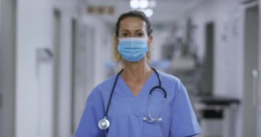 Hastanenin koridorunda yüz maskesi takan beyaz kadın sağlık görevlisinin portresi. Coronavirus covid 19 salgını sırasında sağlık hizmeti